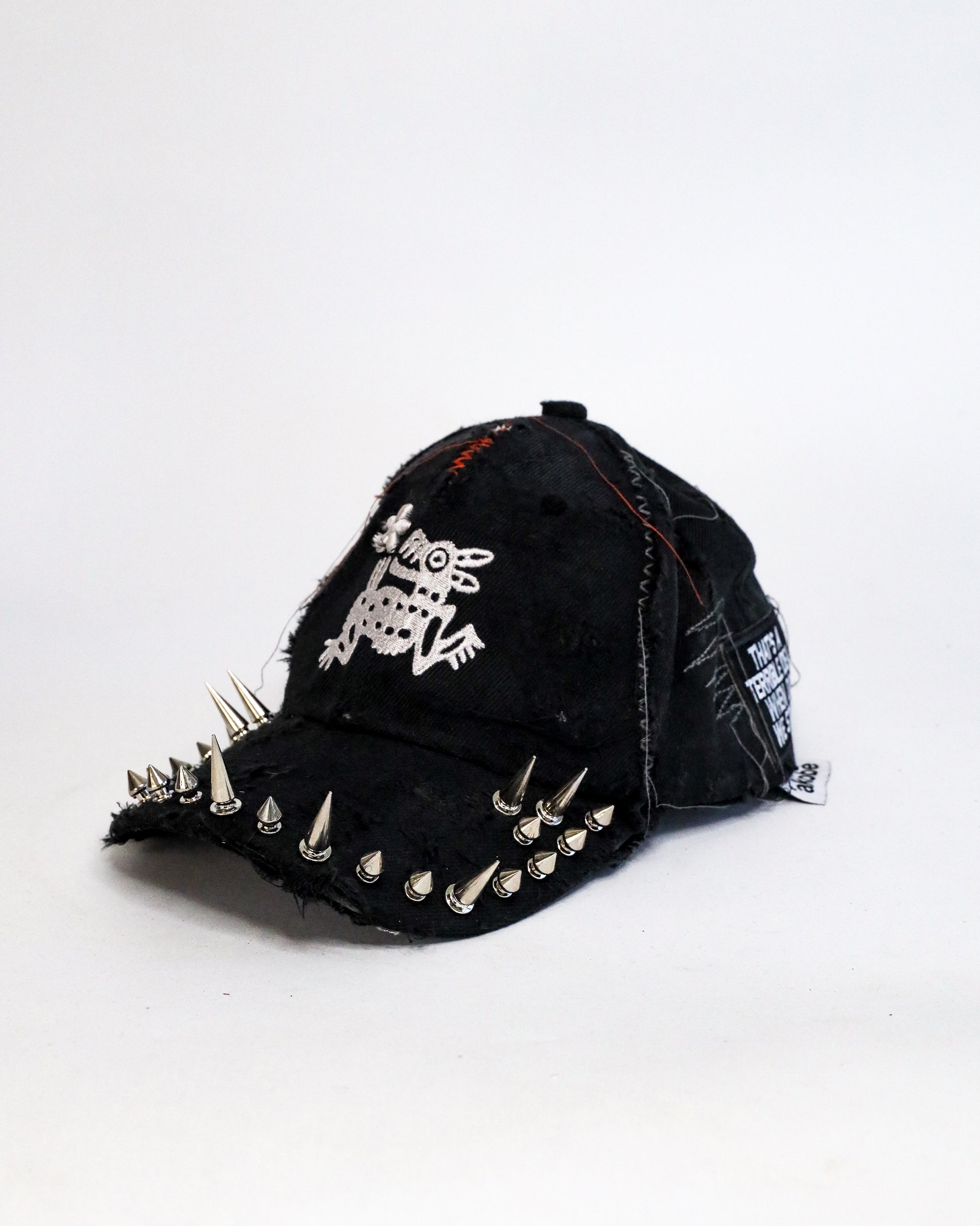 Black cap with spikes and a white logo on a white background
